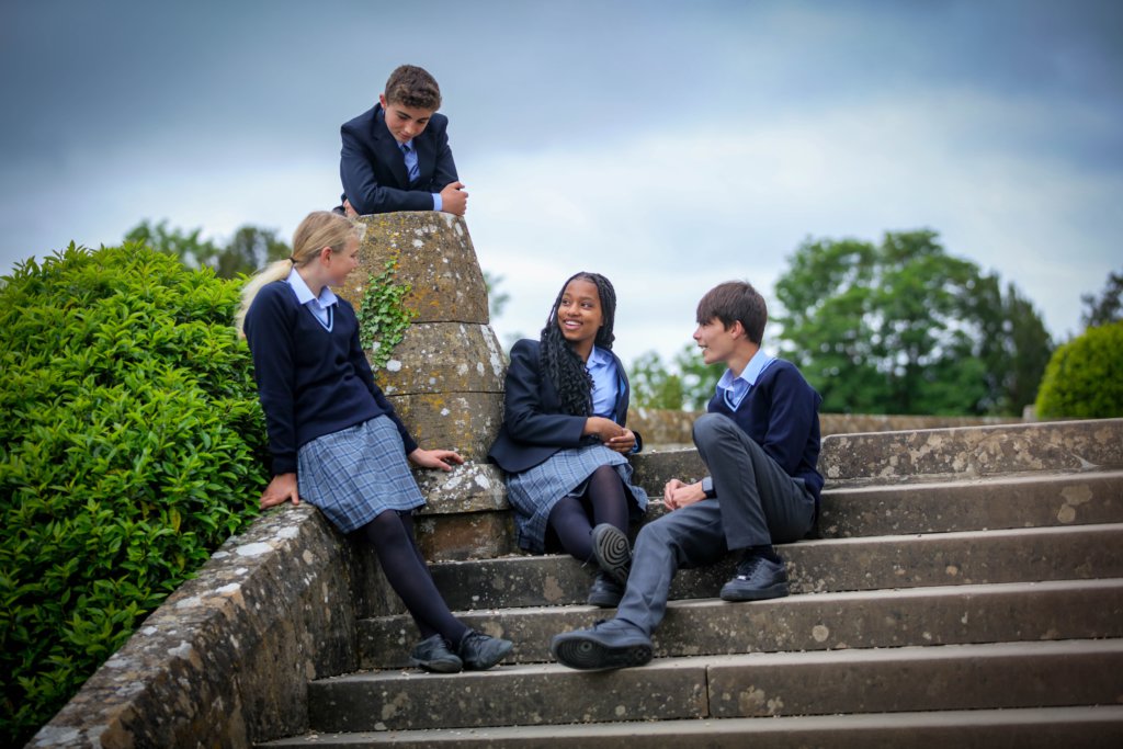 Clayesmore pupils sitting on the steps in the school grounds